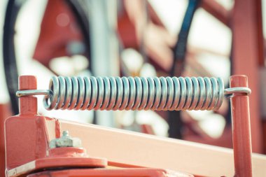 Endüstriyel ya da tarımsal makinenin bir parçası olarak büyük ve sert çelik yay. Teknoloji