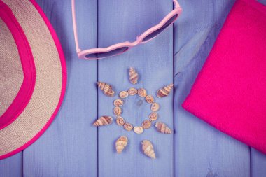 Güneş şeklinde deniz kabukları, güneş gözlüğü ve hasır şapka. Yaz ve dinlenme zamanı için aksesuarlar