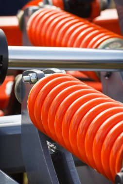 Çelikten yapılmış sert turuncu yay. Büyük endüstriyel ya da tarımsal makinenin bir parçası. Teknoloji