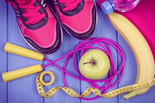 Pair of sport shoes, accessories for fitness and fresh apple. Healthy sporty lifestyles