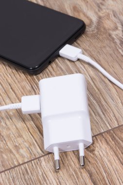 Akıllı telefon, cep telefonu ve şarj aleti boş aküyü şarj etmek için kullanılıyor. Çeşitli aygıtlar şarj etme kavramı