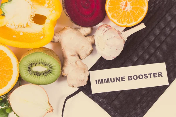 Yazılı bağışıklık güçlendirici, sebzeli taze olgun meyveler ve koruyucu maske. Doğal, sağlıklı vitaminler ve mineraller. Covid-19 zamanlarında faydalı yiyecekler