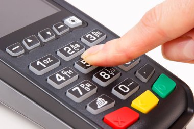 PIN kodunu ödeme terminaline giriş yapan bir kadın eli. Alışveriş için para ödemeden. Kredi kartı okuyucu. Finans kavramı