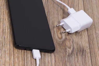 Akıllı telefon, cep telefonu ve şarj aleti boş aküyü şarj etmek için kullanılıyor. Çeşitli aygıtlar şarj etme kavramı