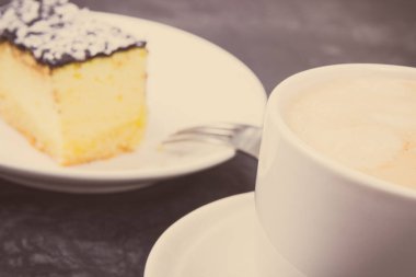 Bir fincan beyaz kahve ve taze pişmiş cheesecake. Tatlı nefis.