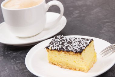 Bir fincan beyaz kahve ve taze pişmiş cheesecake. Tatlı nefis.