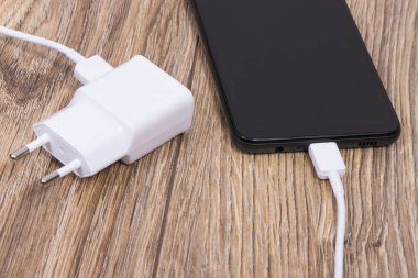 Akıllı telefon, cep telefonu ve şarj aleti boş aküyü şarj etmek için kullanılıyor. Çeşitli aygıtlar şarj etme kavramı
