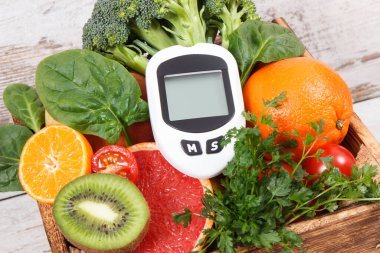 Şeker seviyesini ölçmek ve kontrol etmek için glukometre ve olgun doğal meyve ve sebzeler. Diyabet, sağlıklı yaşam biçimleri ve beslenme kavramı