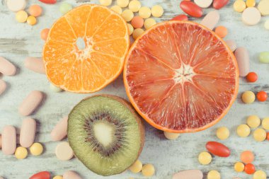 Vitamin ve ilaç içeren taze doğal meyveler. Sağlıklı beslenme ve takviyeler arasında seçim yapmak.