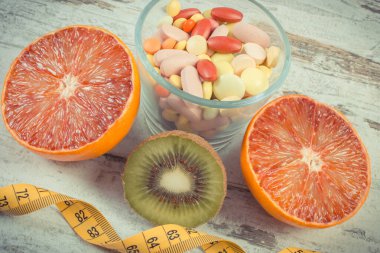 Taze doğal meyve, mezura ve ilaç. Zayıflamak ve meyve yemek ile bağışıklığı güçlendirmek için takviye almak arasında seçim yapmak