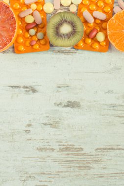 Vitamin ve ilaç içeren taze doğal meyveler. Sağlıklı beslenme ve takviyeler arasında seçim yapmak. Metin veya yazı için boşluk kopyala