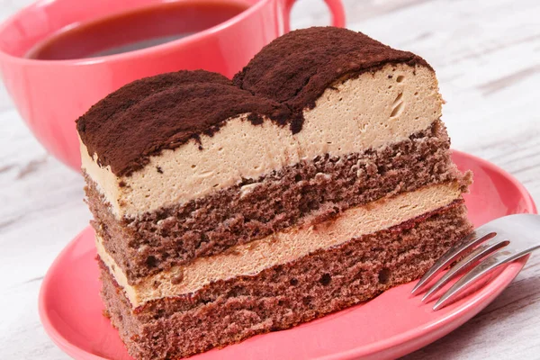 Tasty creamy tiramisu cake on glass plate and black coffee. Delicious dessert for different occasions