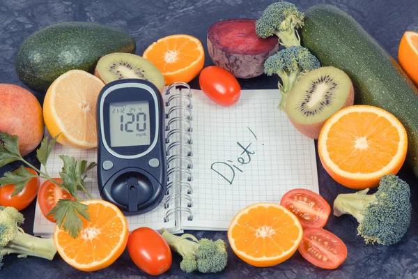Glucometer with result of sugar level, fresh fruits with vegetables and notepad with word diet. Slimming and healthy food for diabetic concept