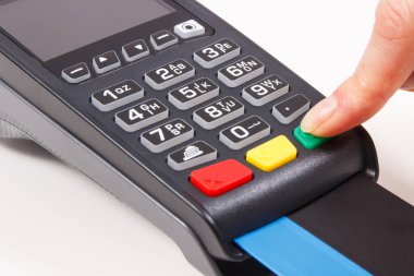 PIN kodunu ödeme terminaline giriş yapan bir kadın eli. Alışveriş için para ödemeden. Kredi kartı okuyucu. Finans kavramı