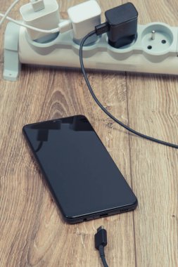 Akıllı telefon, cep telefonu ve elektrik hattına bağlı şarj cihazları. Çeşitli aygıtlar şarj etme kavramı