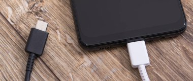 Şarj kablosu olan akıllı telefon. Cep telefonu şarj kavramı