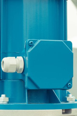 Blue electrical box used for wiring connections and part of electric engine. Technology and detail of industrial machine