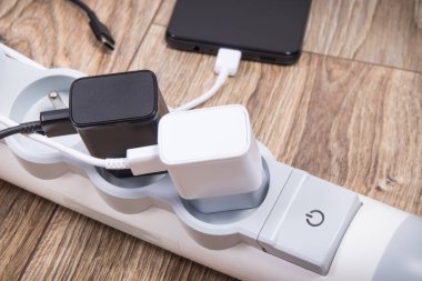 Akıllı telefon, cep telefonu ve elektrik hattına bağlı şarj cihazları. Çeşitli aygıtlar şarj etme kavramı