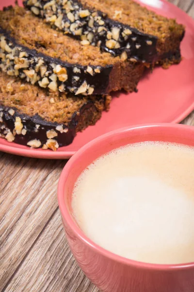 Fresh baked zucchini dough and cup of white coffee on wooden board. Delicious dessert