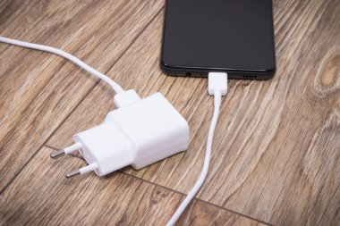 Akıllı telefon, cep telefonu ve şarj aleti boş aküyü şarj etmek için kullanılıyor. Çeşitli aygıtlar şarj etme kavramı