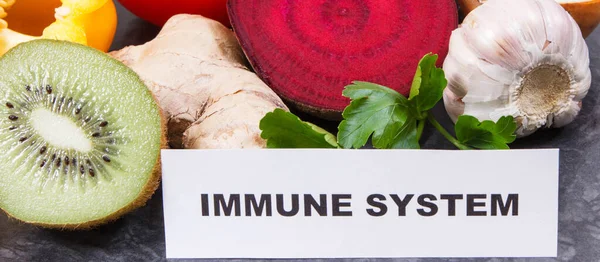 Inscription immune system with fresh ripe fruits and vegetables. Source natural vitamins, minerals and dietary fiber