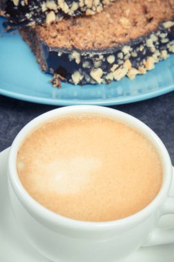 Mavi tabakta kabak ve bir fincan beyaz kahveden yapılmış taze pişmiş hamur işi. Tatlı nefis.