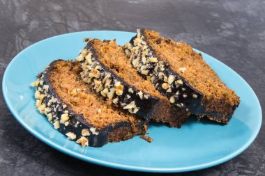 Pieces of zucchini dough with nuts and raisins on blue glass plate. Delicious dessert