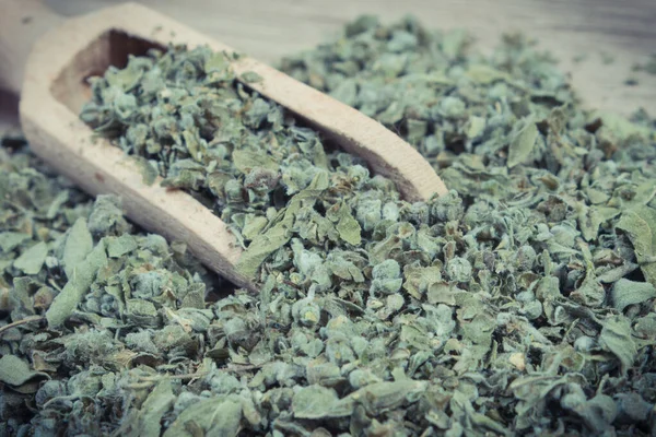 木製のスクープで乾燥した緑のマルジョラムのヒープ 異なる料理のためのスパイス — ストック写真
