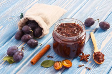 Taze erik reçel veya marmelat cam kavanoz, olgunlaşmış meyve ve baharat panoları, sağlıklı tatlı tatlı kavramı