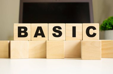 BASIC kelimesi ofis masasında dizüstü bilgisayarın önünde duran tahta küplere yazılmıştır. İş konsepti.