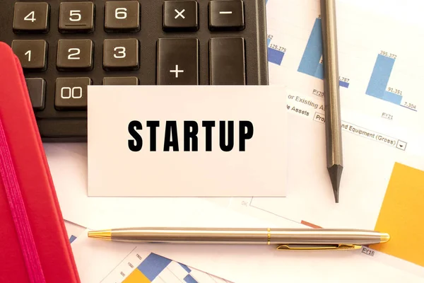 Tekst Startup Witte Kaart Met Metalen Pen Rekenmachine Financiële Grafieken — Stockfoto