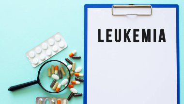 Uyuşturucunun yanındaki masada üzerinde kağıt olan bir pano var. Yazı LEUKEMIA.