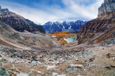 Moraine Gölü 'ndeki Kanada Kayalık Dağları' nda Eyfel Kulesi lakaplı Eiffel Kulesi 'nin bulunduğu geniş açılı Panorama Karlı On Tepe Vadisi' nin yoğun bulutlarla kaplı olduğu Larch Vadisi 'ne açılıyor..