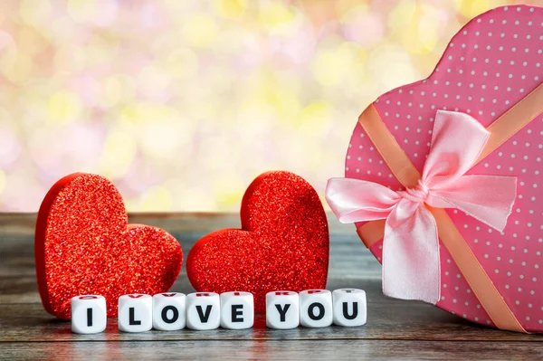 粉色心形情人节礼物盒放在木制桌子上 上面有两颗心 我爱你 的信息 复制空间 — 图库照片
