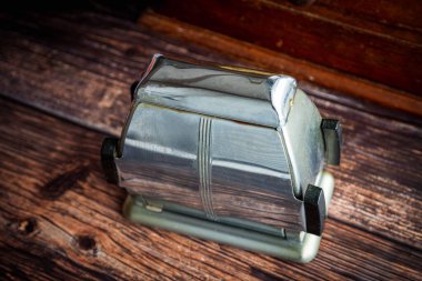 Eski, paslanmaz çelik ekmek kızartma makinesi ahşap mutfak masasında..