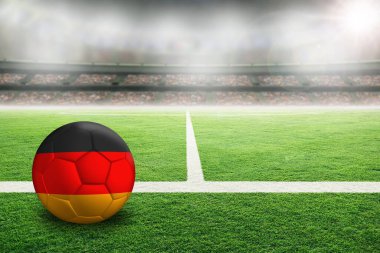 Açık hava stadyumunda Almanya 'nın boyalı bayrağıyla futbol. Arkaplanda sığ alan derinliği olan ön plan ve futbol topuna odaklan ve boşluğu kopyala.