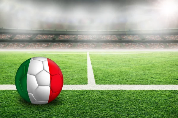 イタリアの国旗が描かれた明るい屋外スタジアムでサッカー 前景に焦点を当て 背景とコピースペースにフィールドの浅い深さを持つサッカーボール — ストック写真