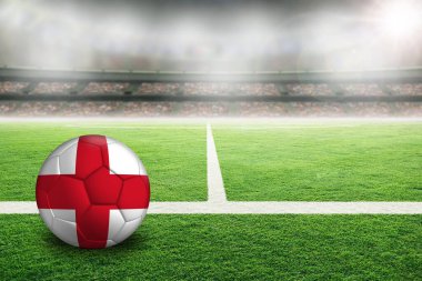İngiltere 'nin boyalı bayrağıyla aydınlık bir stadyumda futbol. Arkaplanda sığ alan derinliği olan ön plan ve futbol topuna odaklan ve boşluğu kopyala.