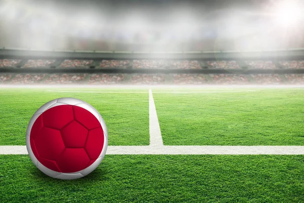 Piłka Nożna Jasno Oświetlonym Stadionie Malowaną Flagą Japonii Skup Się — Zdjęcie stockowe