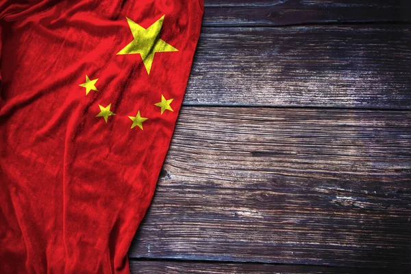 Chinese flag on rustic wooden background for Martyrs Day, China National Day or Labor Day concept.