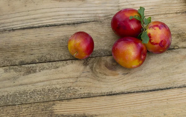 木製のテーブルの上の赤い梅 — ストック写真