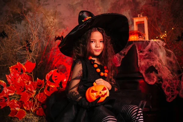 Egy Boszorkányjelmezes Kislány Sötét Háttérben Egy Tököt Tart Kezében Készülődöm — Stock Fotó