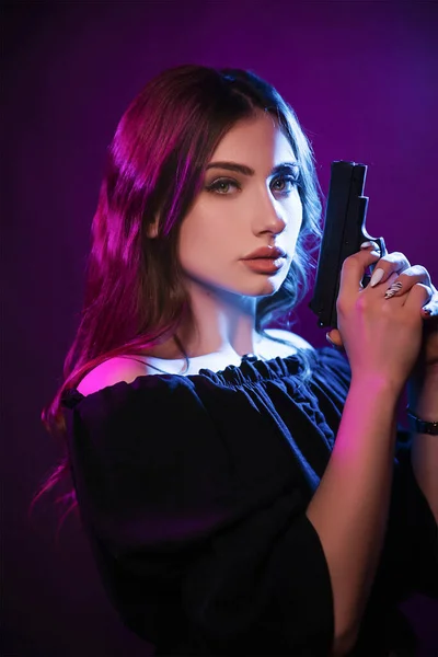 Молодая Женщина Темноте Клубе Держит Пистолет Вечеринка Голубом Розовом Свете — стоковое фото