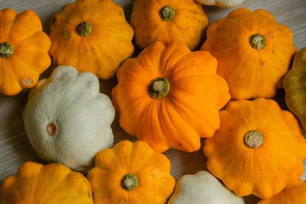スクワッシュは黄色の背景にあります 秋のテーブルの上にはオレンジのカボチャのパティッションがあります 豊かな収穫 — ストック写真
