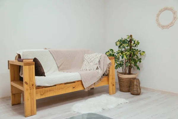 Holzsofa Skandinavischen Stil Mit Karo Und Kissen Zimmerpflanzen Innenraum Blumen lizenzfreie Stockbilder