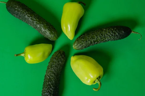 Αγγούρια Και Πιπεριές Βρίσκονται Πράσινο Φόντο Υγιεινή Τροφή Χορτοφαγία — Φωτογραφία Αρχείου
