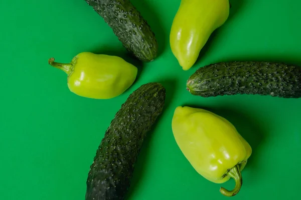 Αγγούρια Και Πιπεριές Βρίσκονται Πράσινο Φόντο Υγιεινή Τροφή Χορτοφαγία — Φωτογραφία Αρχείου