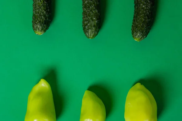 キュウリとピーマンは緑の背景にあります 健康食品 菜食主義 — ストック写真