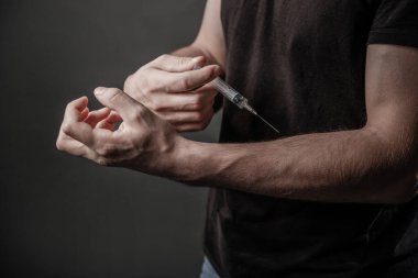 Uyuşturucu konsepti. Eroin enjekte eden şırınga bağımlısı. Damarları kapalı eller