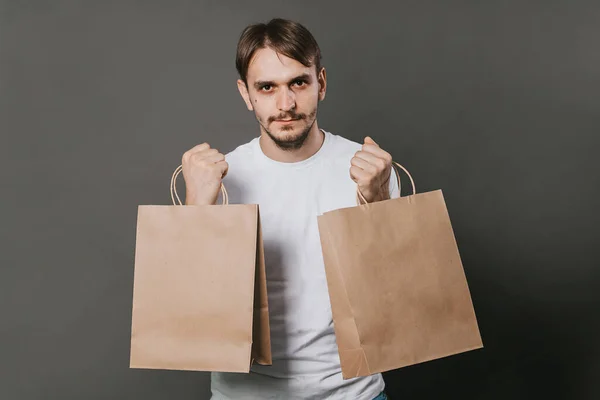 Man White Shirt Two Paper Bags His Hands Gray Background — Stock Photo, Image